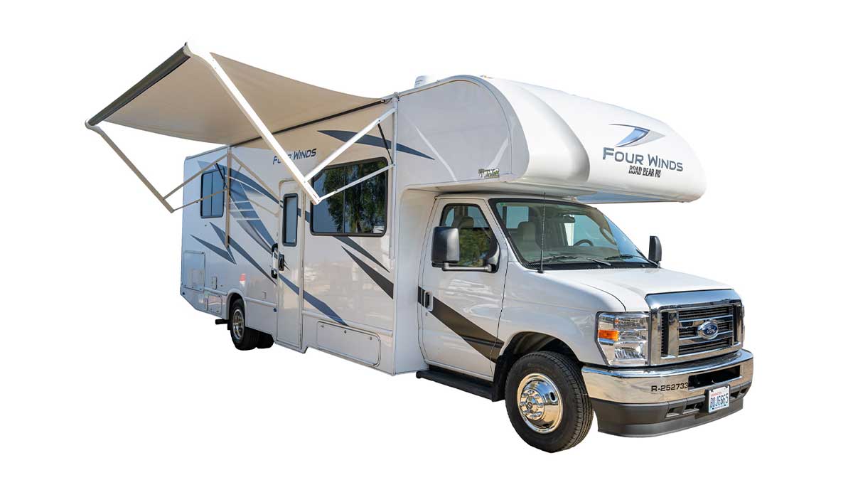 A white with dark colour pattern stripes Road Bear overcab motorhome. Class C 29-31. With an canopy awning pulled out. With a white background. 