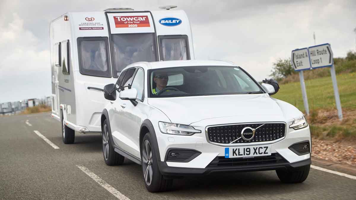 White volvo towing a caravan 