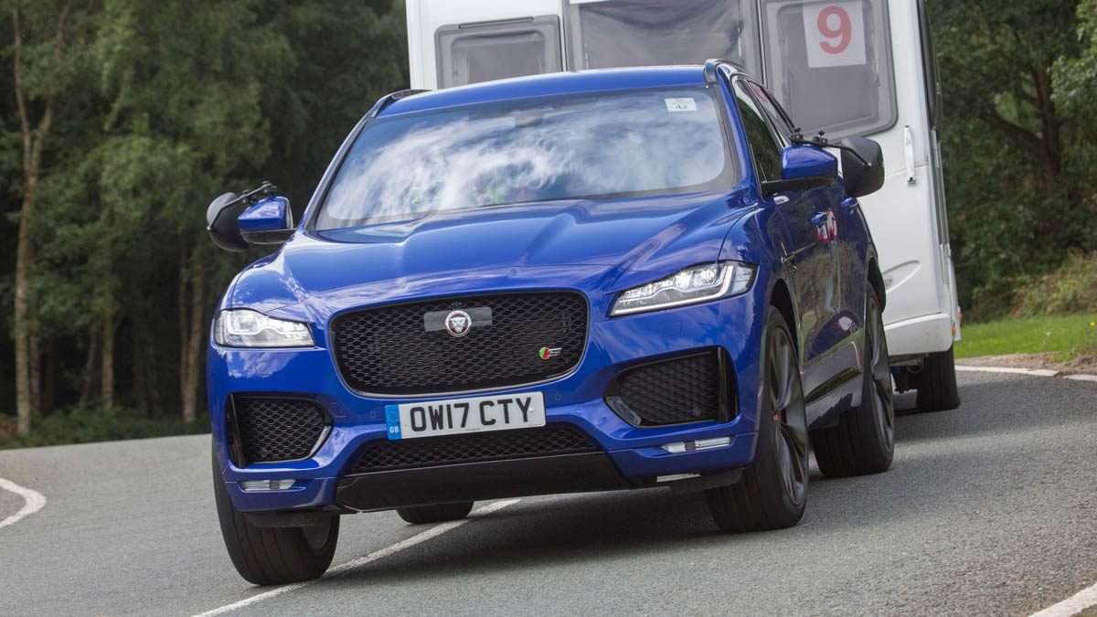 Blue Jaguar car towing a caravan close up