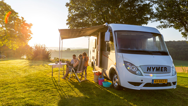 Sun setting on a family relaxing under their caravan awning