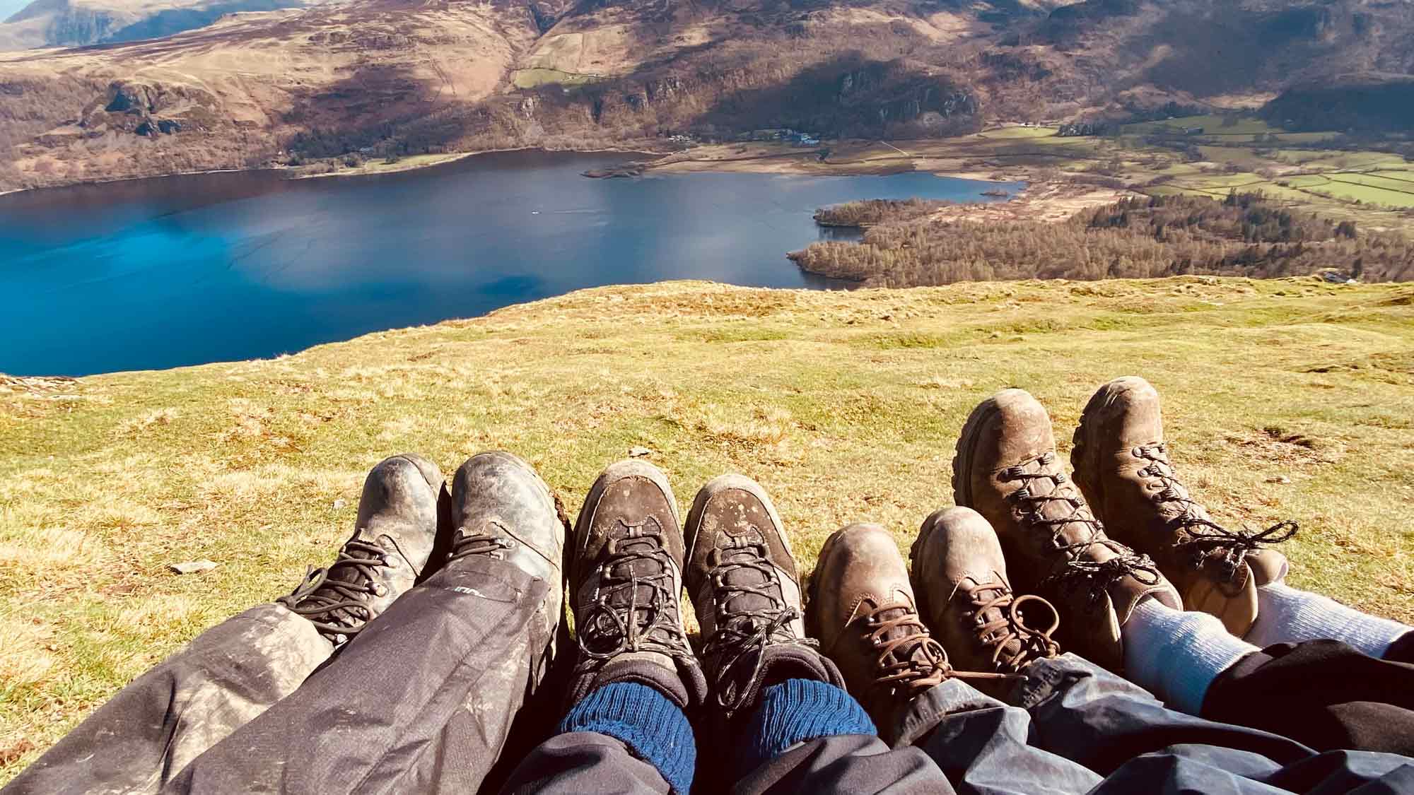 four sets of boots side by side, looking down to Derwent Water