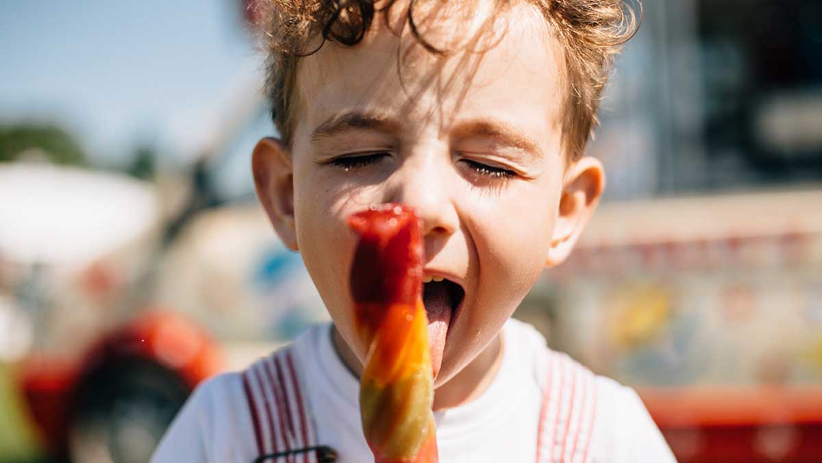 Young boy eating an ice lolly