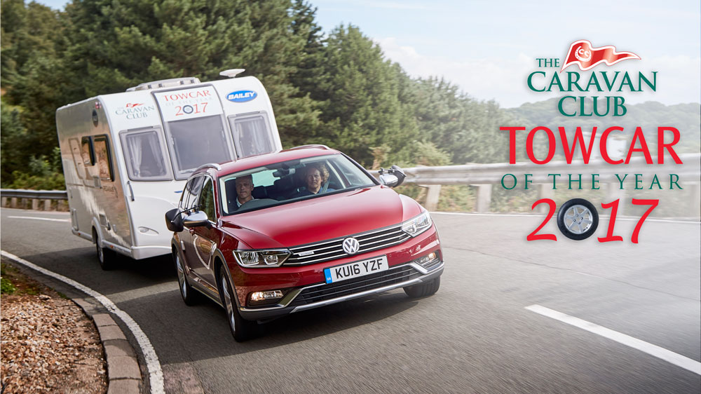 Red towcar towing a caravan along a mountain road - Caravan Club Towcar of the year 2017 on the right
