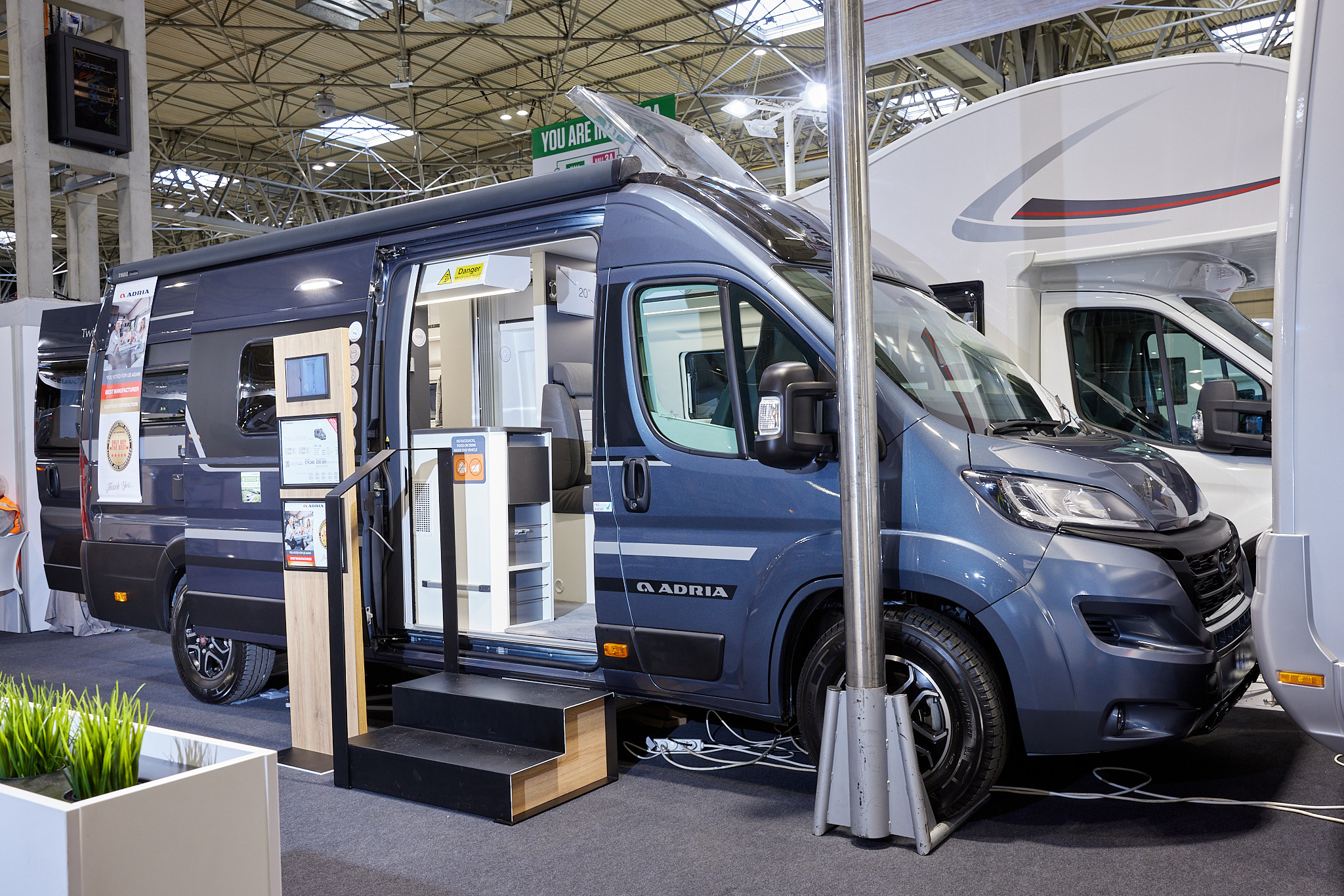 Adria Twin Supreme 640 SLB exterior, van conversion is blue the sliding door is open showing into the interior, with a double step to gain easy access and the roof light is open.  