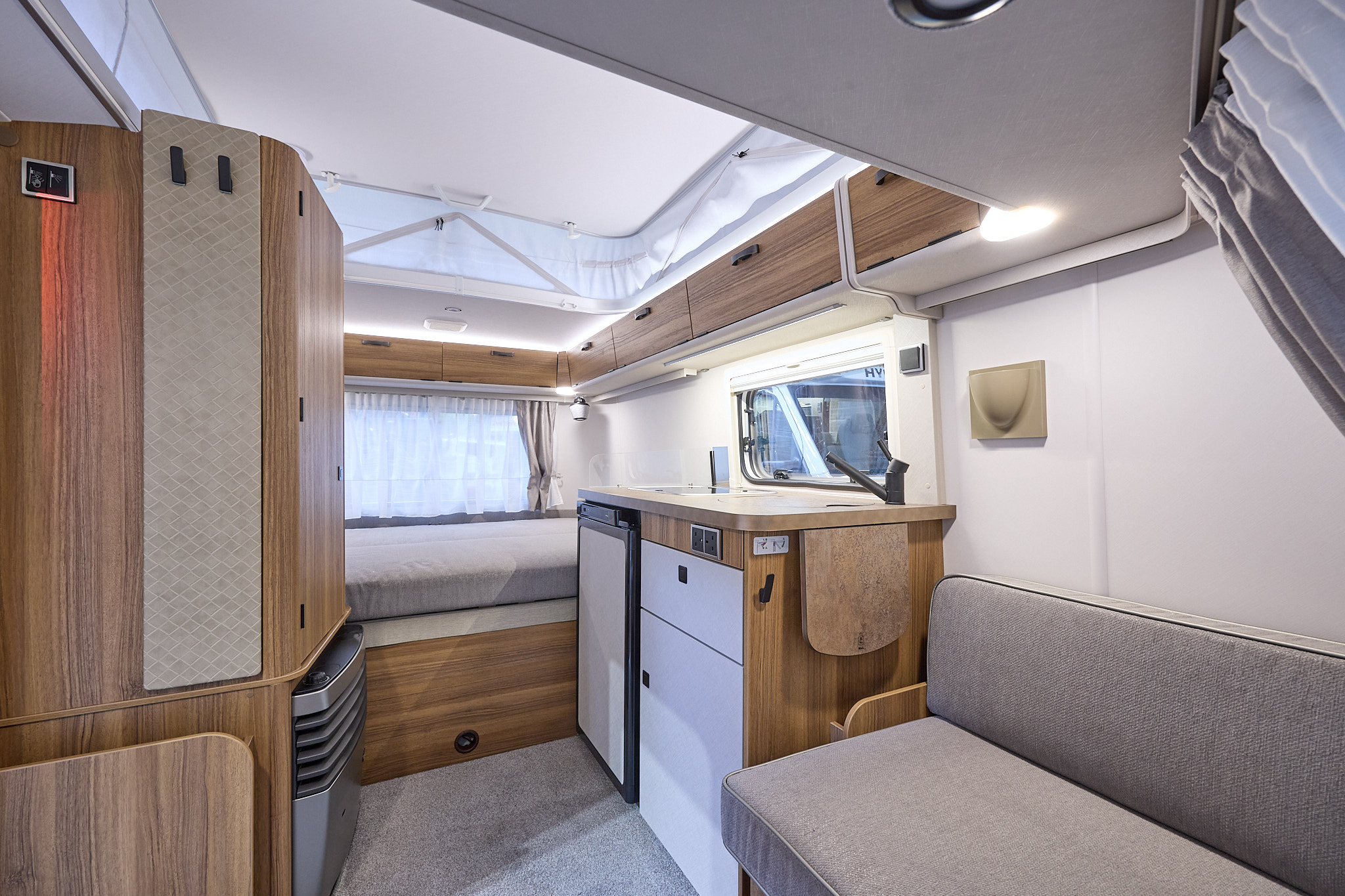 Eriba Touring 310 interior, grey upholstery, wood furniture, pop top roof, lounge, kitchen