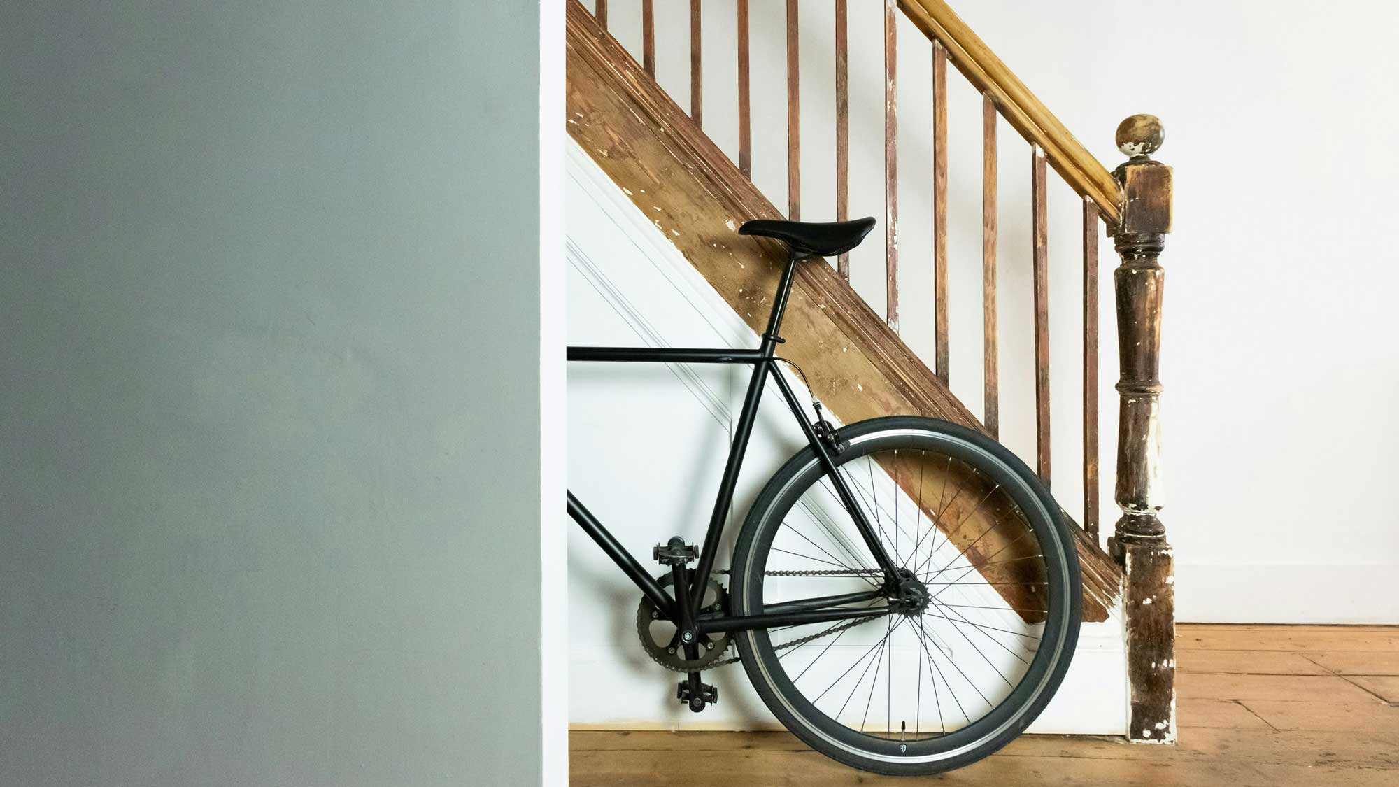 racing bicycle propped up against a wooden staircase