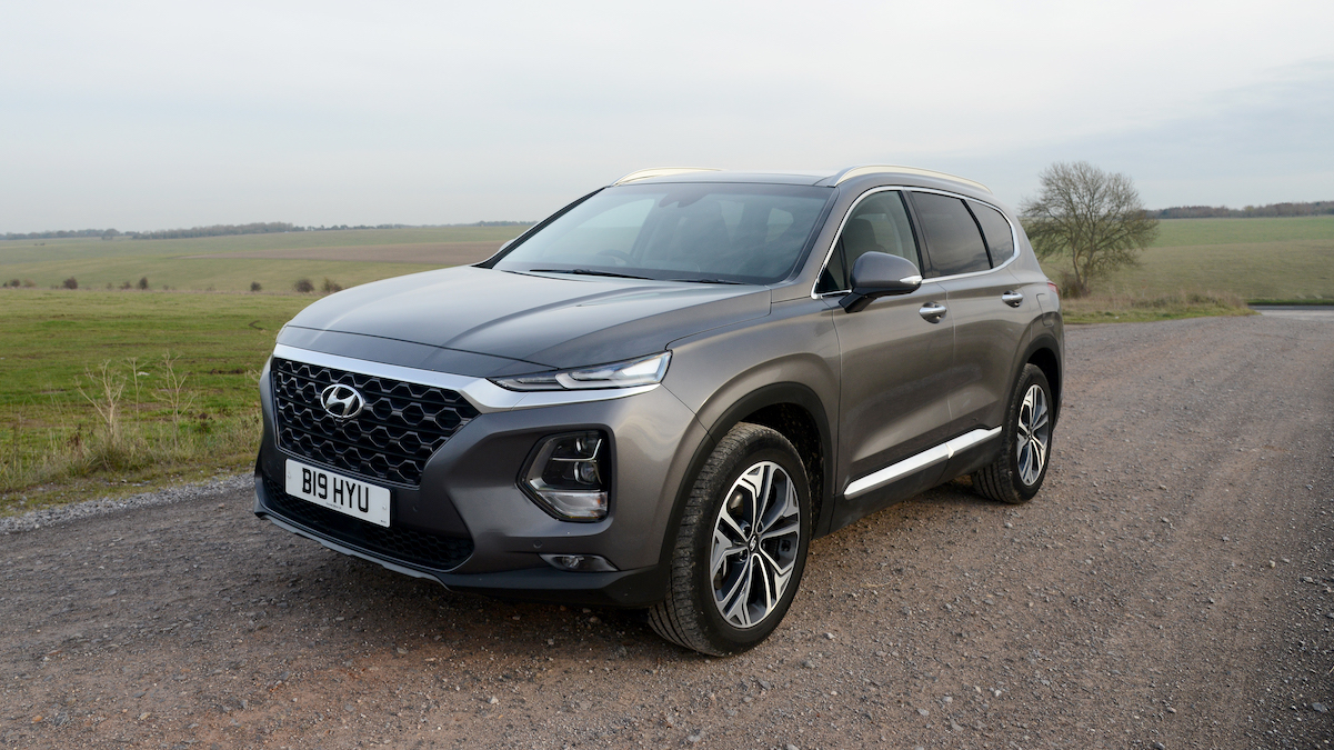 Dark grey Hyundai driving along a road