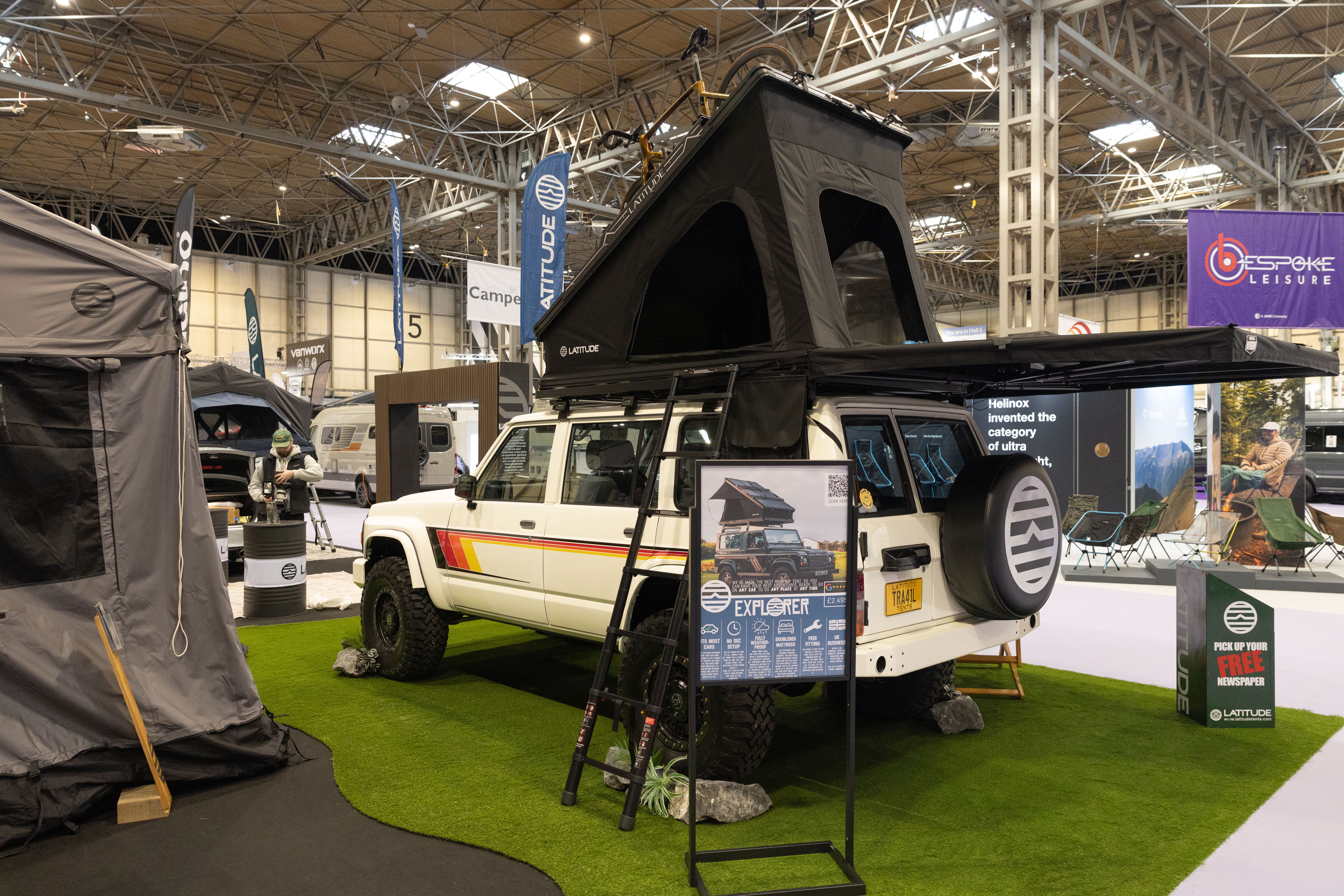 The Latitude Tents Explorer has black canvas and has platform.  There is a black ladder to gain access.  It is displayed on a white 4x4 vehicle.