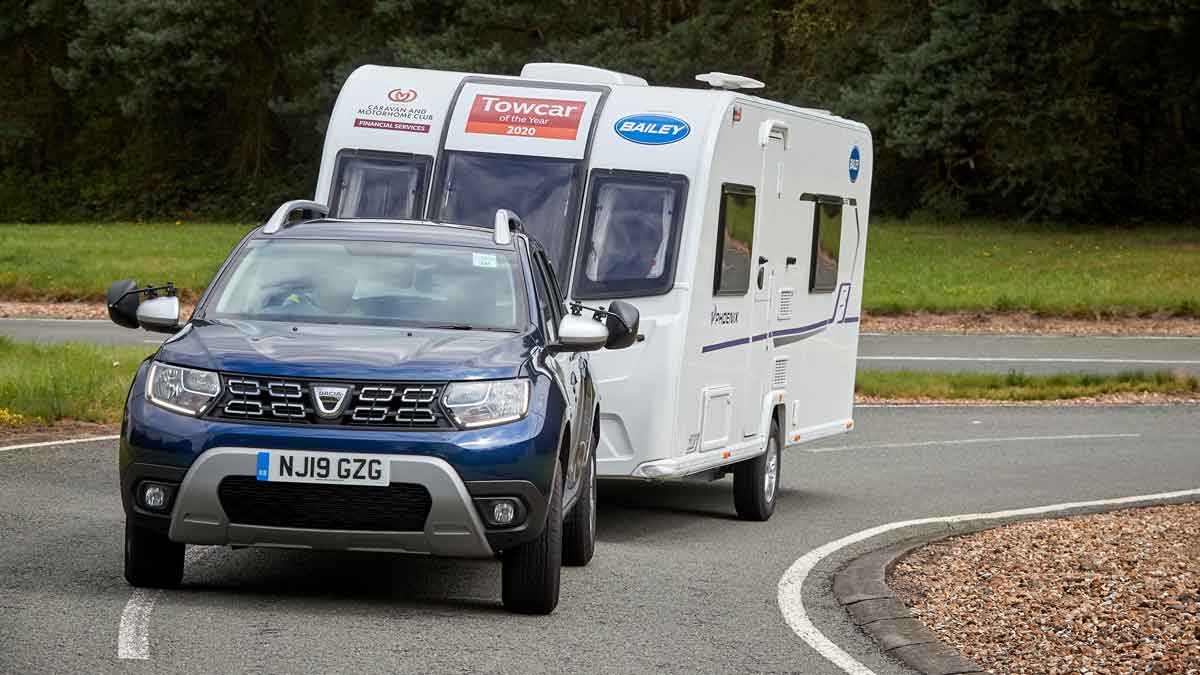 Blue Dacia Duster towing caravan