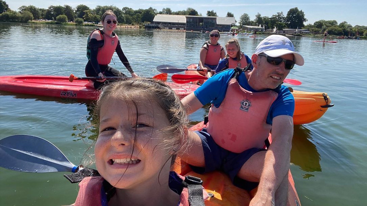 A family paddling kayaks in the water, enjoying a sunny day outdoors