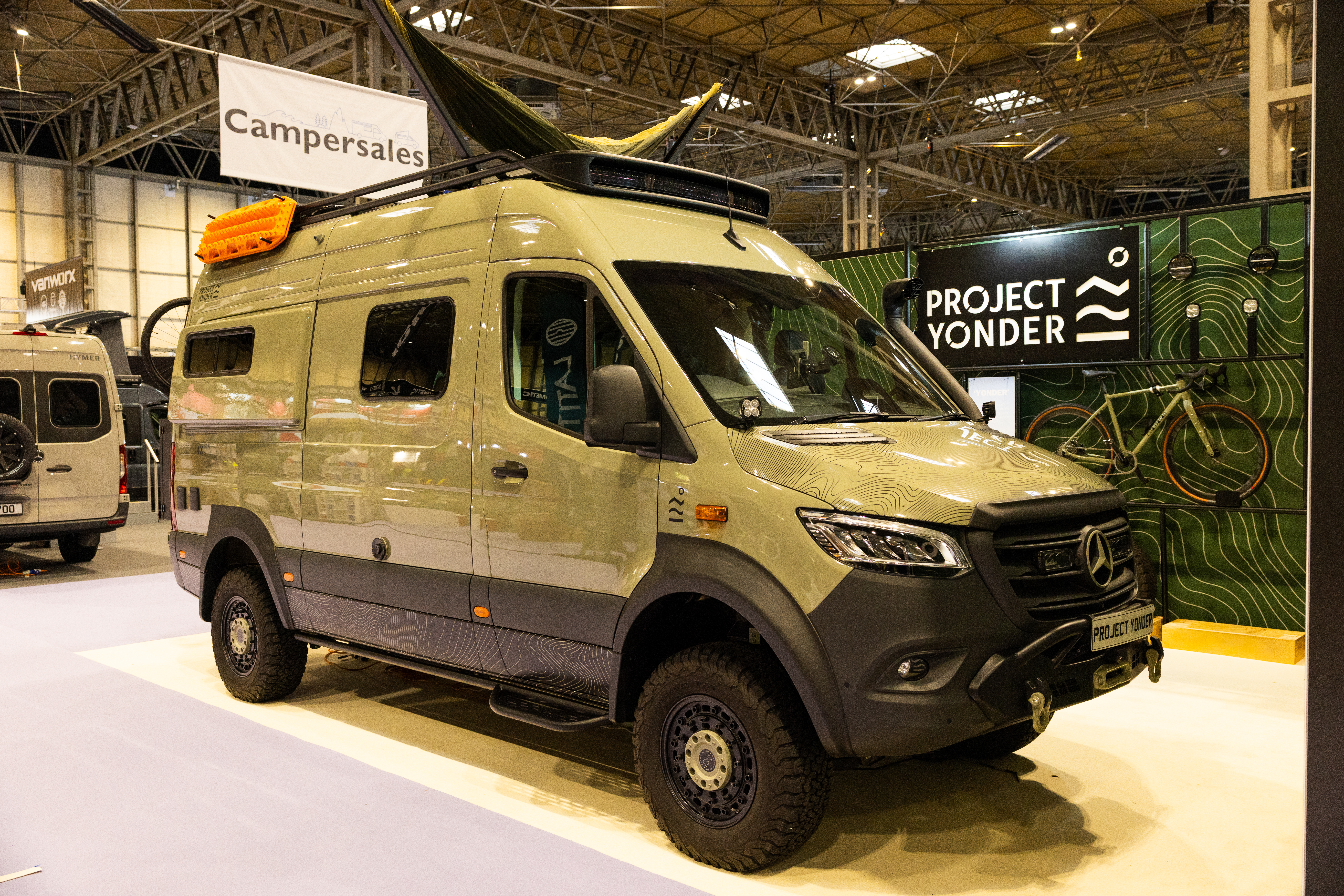 The Project Yonder Nomad 4X is a pale green with black trim.  It has a hammock on its roof.