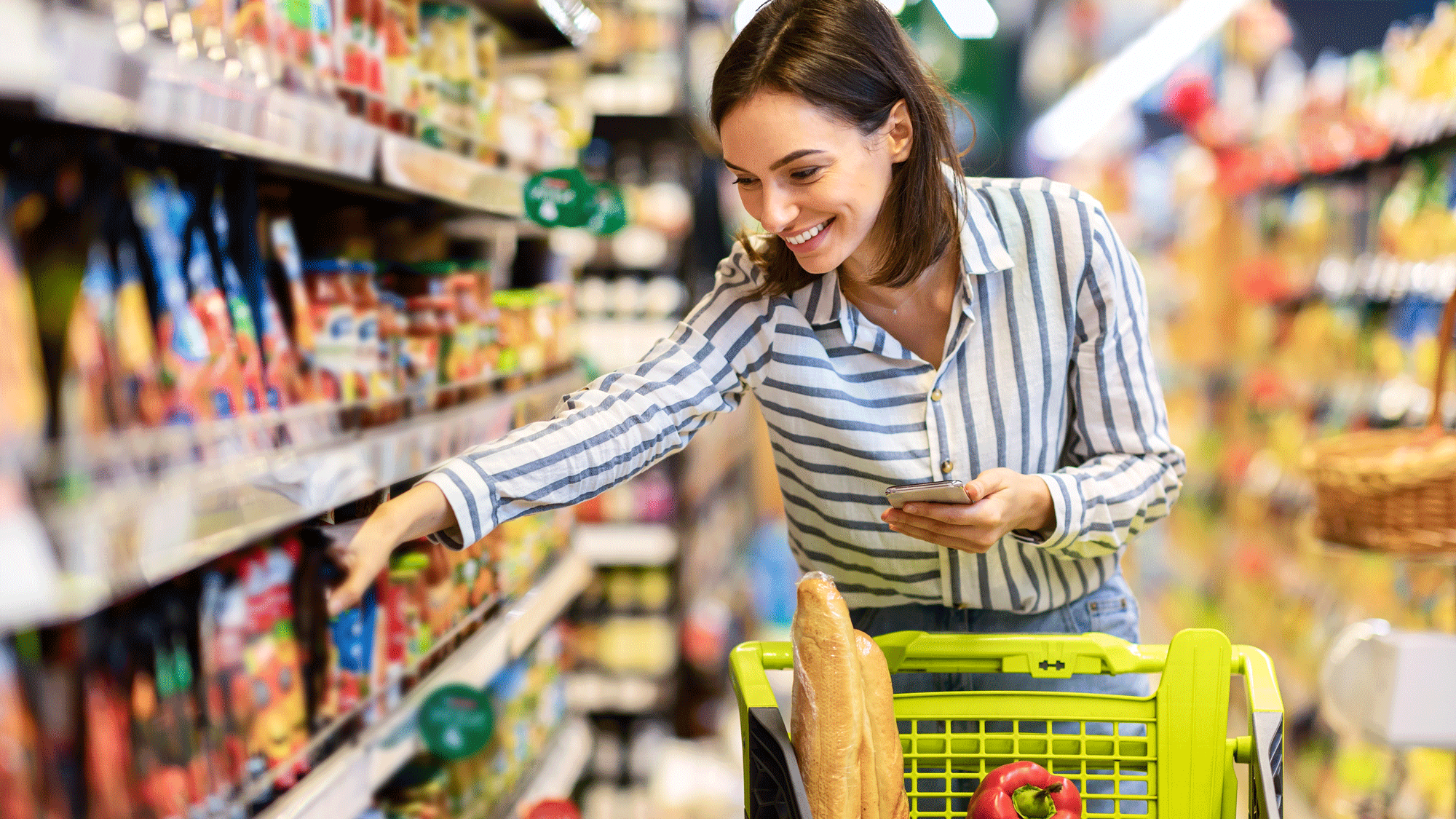 A woman in a supermarket looking at some products on a shelf