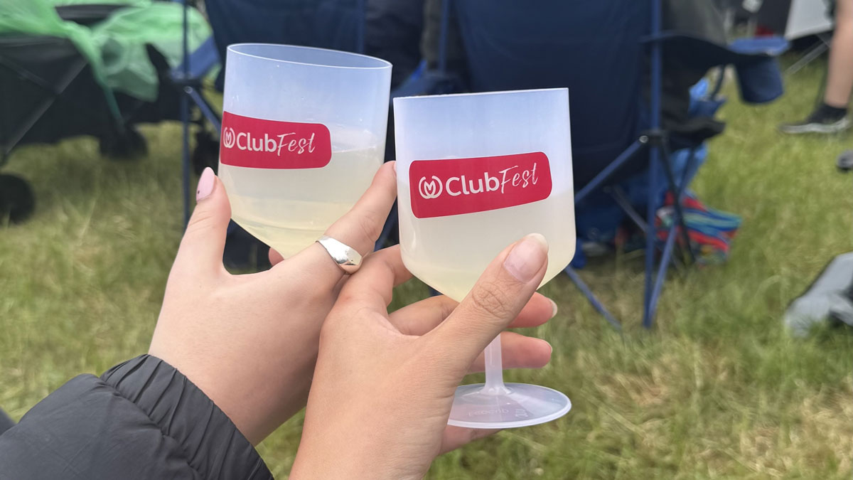 two friends enjoying a glass of wine in the Clubfest special edition reusable wine glasses