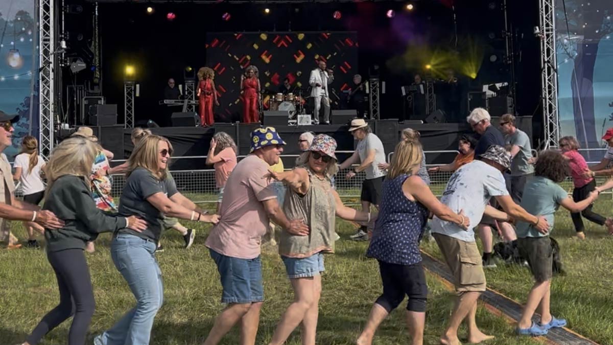 A conga line winding in front of the stage as Roy Hemming performs 