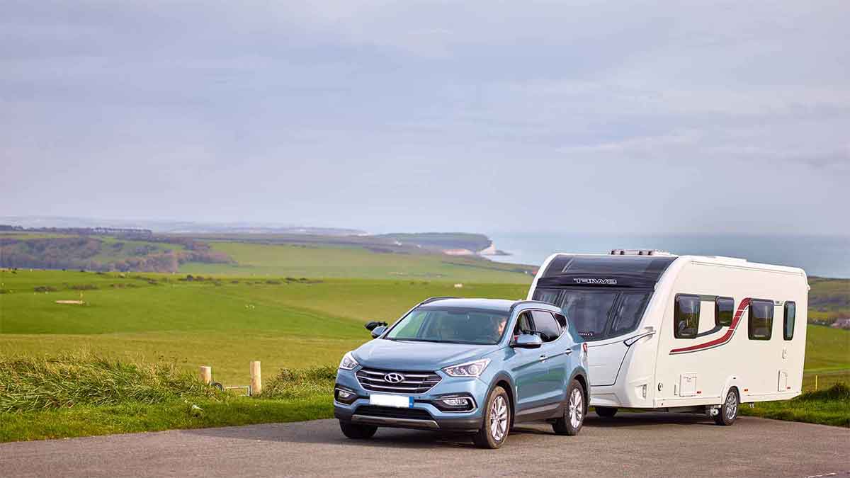 Car towing a caravan on a road