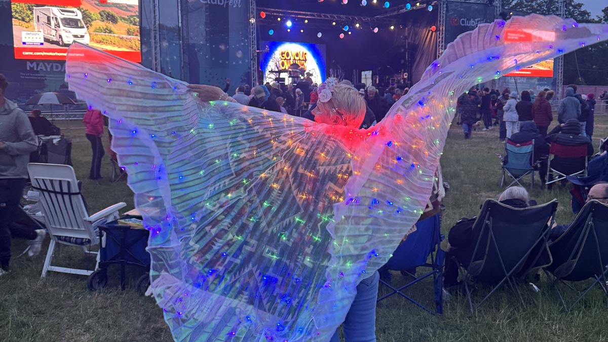 a ClubFest-goer shows off her light-up wings floating out behind her