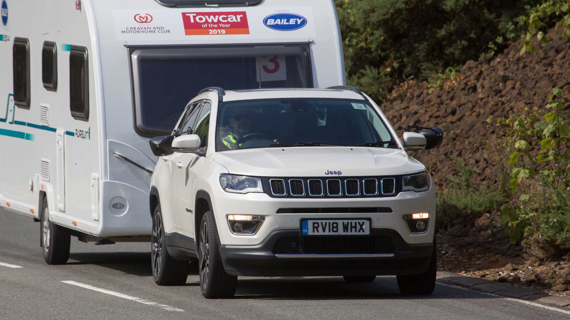 White Jeep Compass towing a caravan