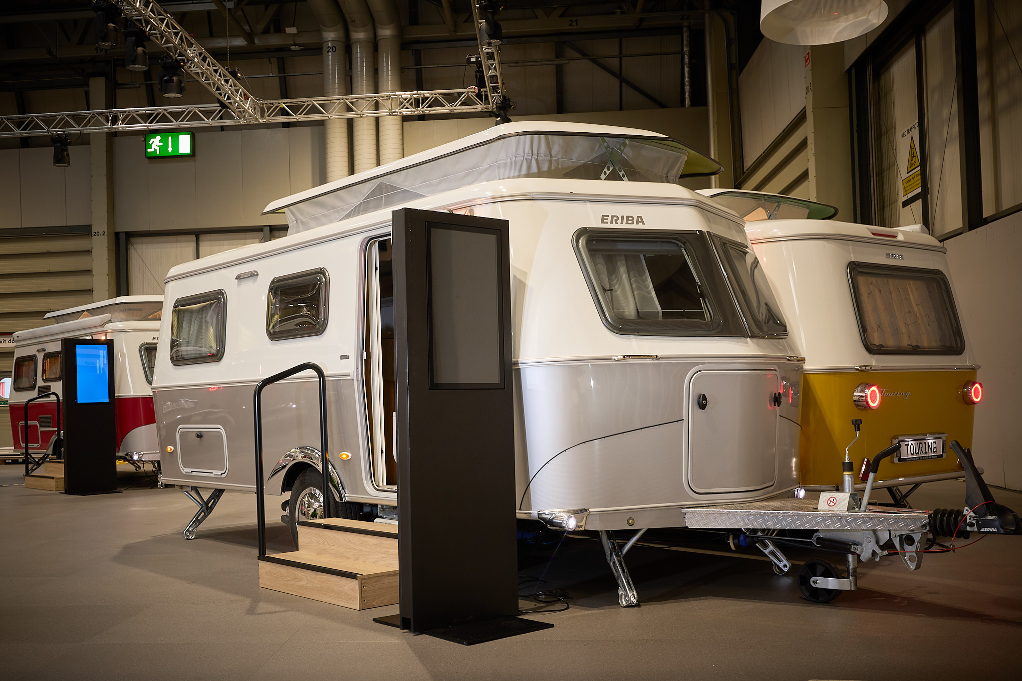 Eriba Touring 630 Legend's exterior is white and silver.  The pop top roof is open.  There are two wooden steps into the interior.
