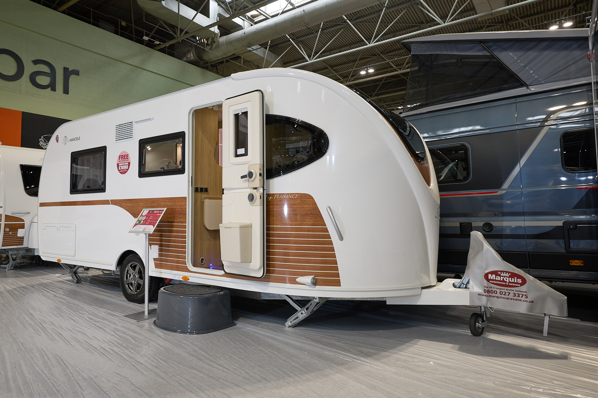 La Mancelle Liberty 490SA's exterior is white with brown panelling.  The caravan has an unique style and comes together at a point at the front.