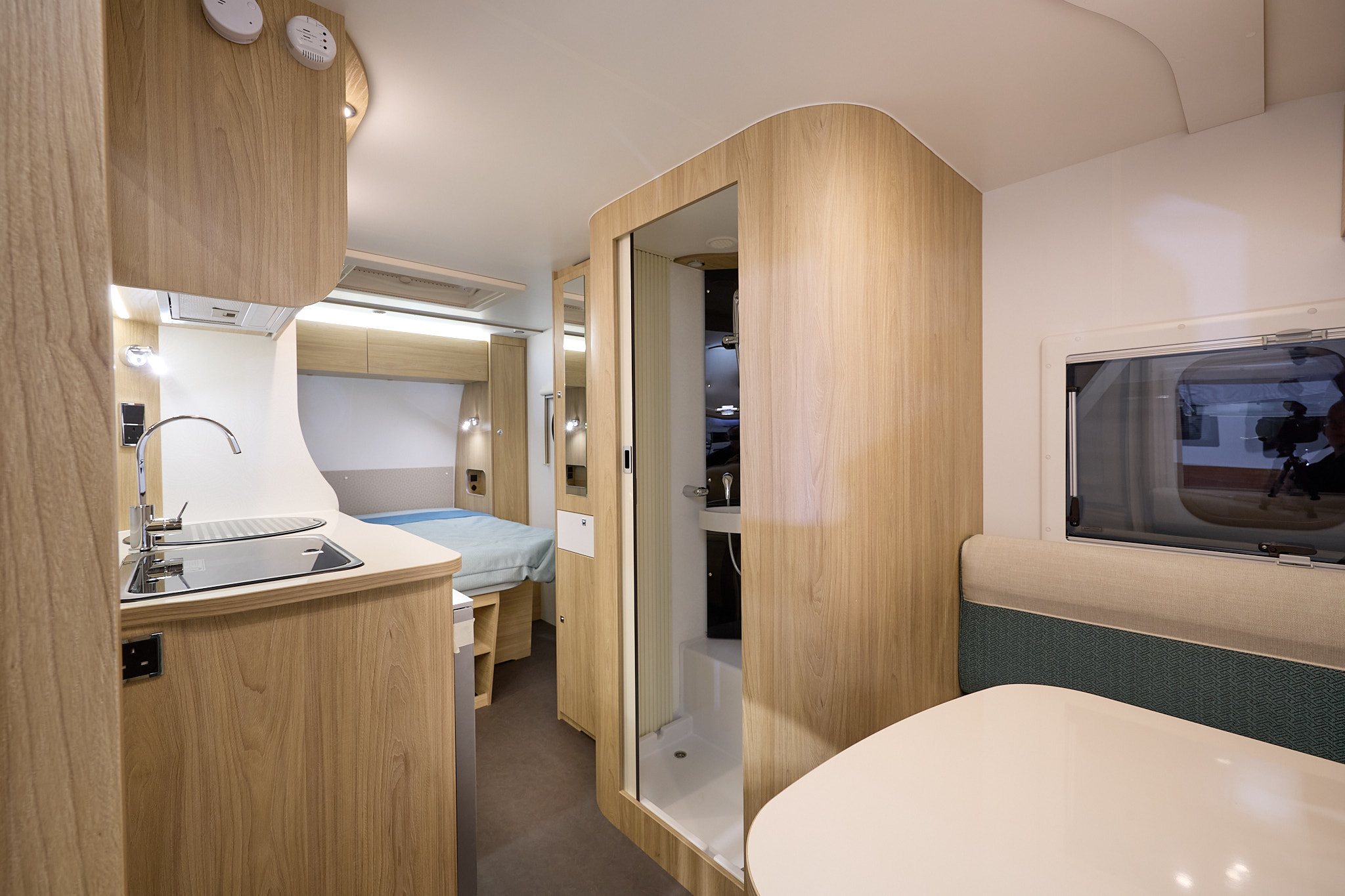 La Mancelle Fantaisy 440CL's interior has wooden furniture and a front dinette.  The kitchen sink is on the left hand side, opposite the shower.  The fixed bed is at the rear. 