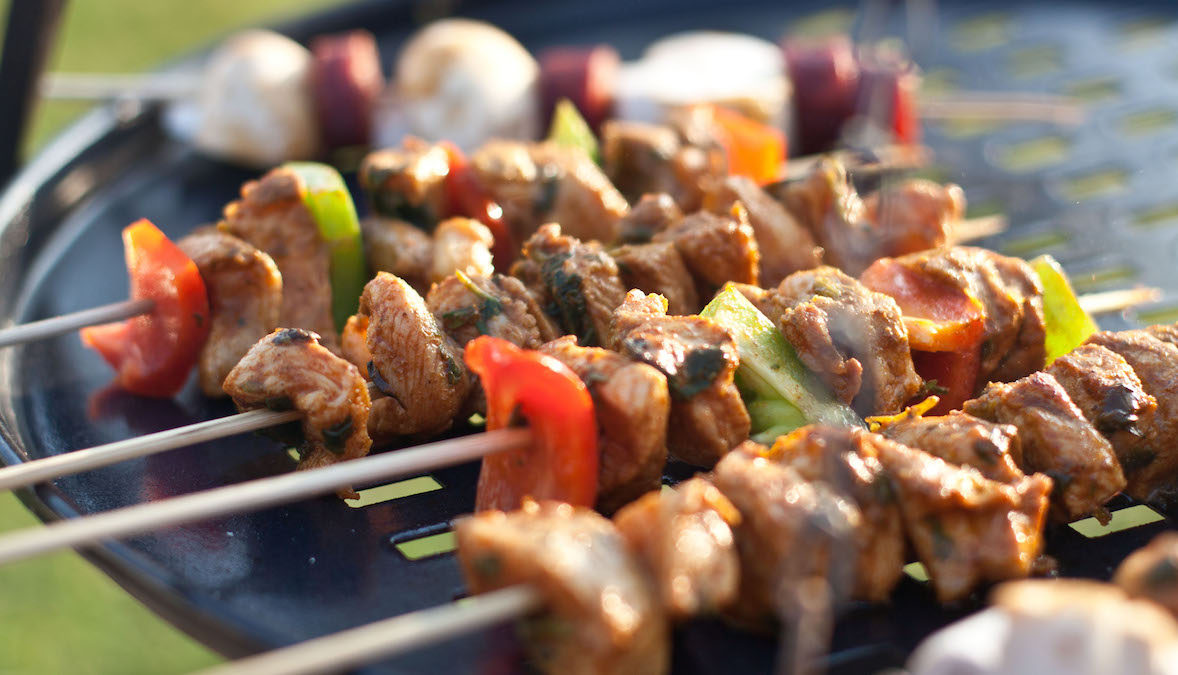 Pork kebabs with peppers cooking on a black barbecue