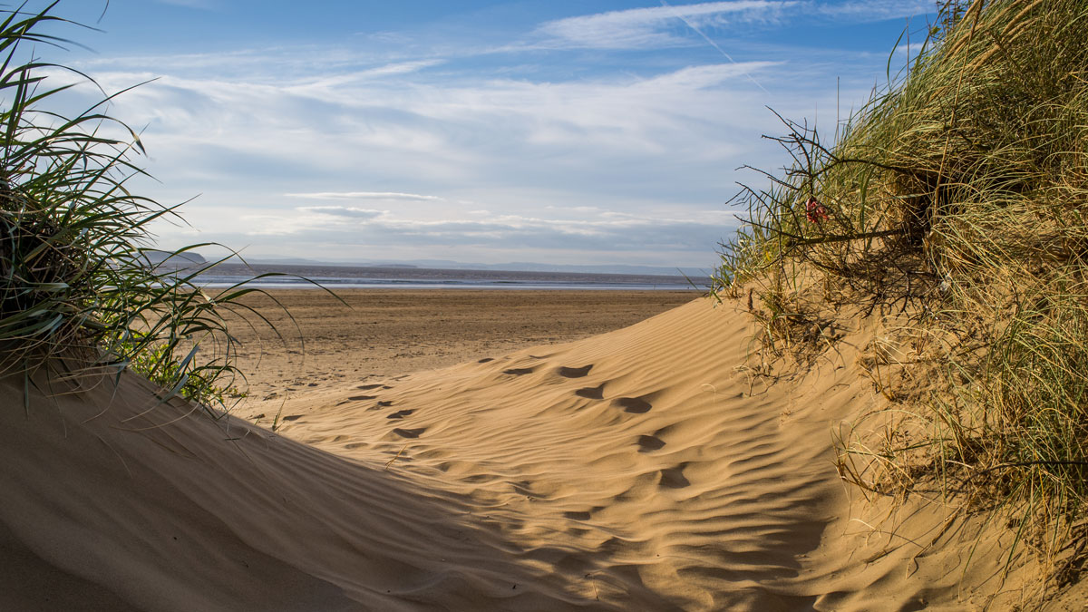 footsteps in between two sand dunes at Brean Sands Beach, Somerset