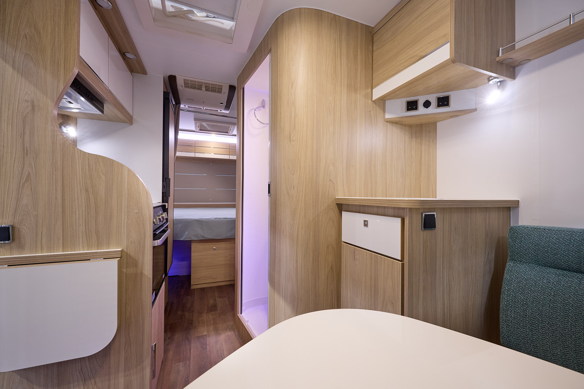 La Mancelle Liberty 490SA's interior has a dinette at the front, the washroom is in the centre and has purple accent lighting.  There is a fixed rear bed.