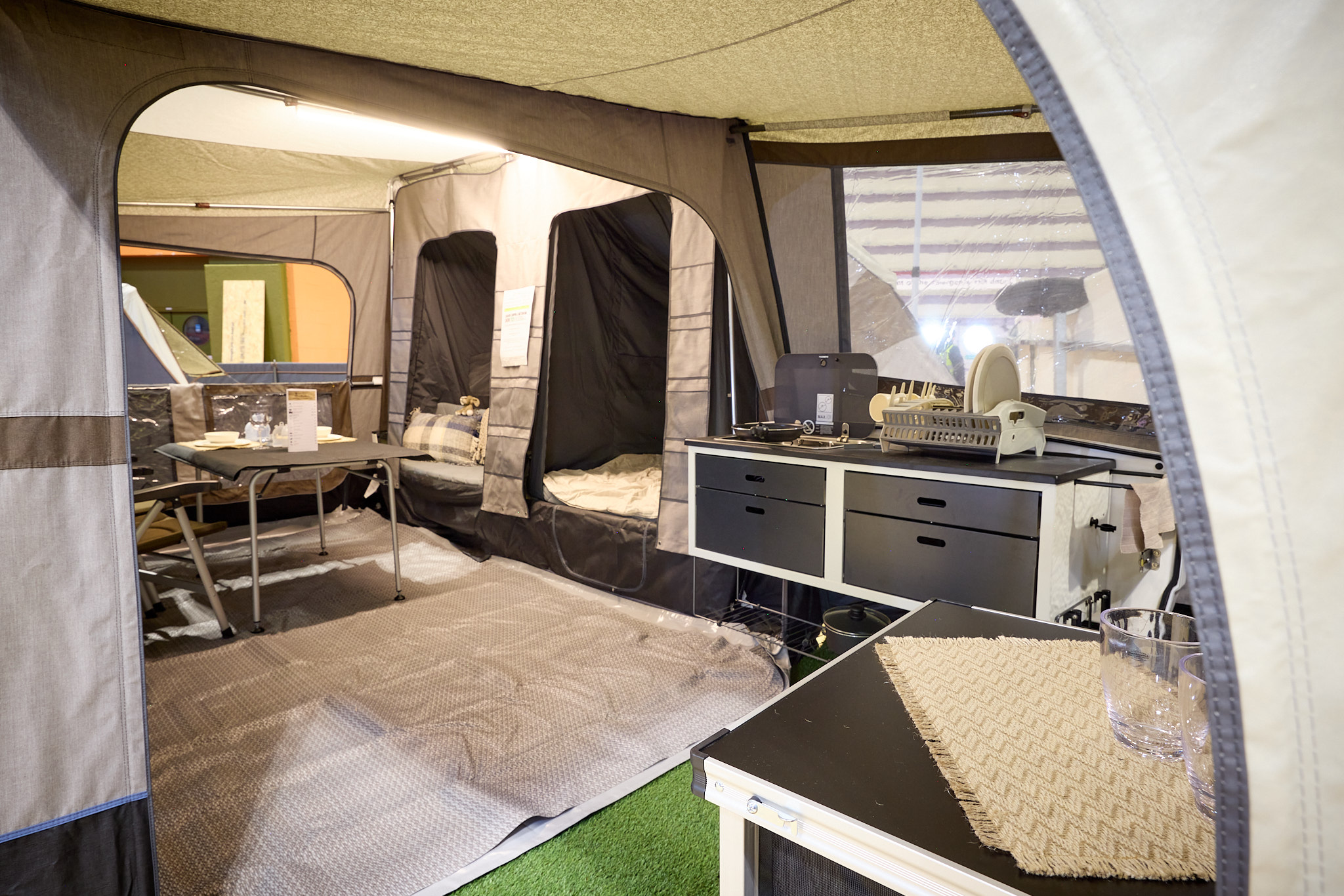 The Camp-Let Earth’s kitchen has two units, there is a ground sheet and the two bedroom doors are open, there is a dining table and chairs in the main tent.