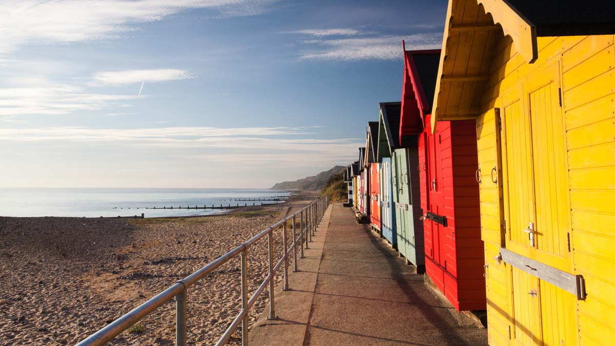 Yellow, red and green beach huts lining Cromer Beach, Norfolk