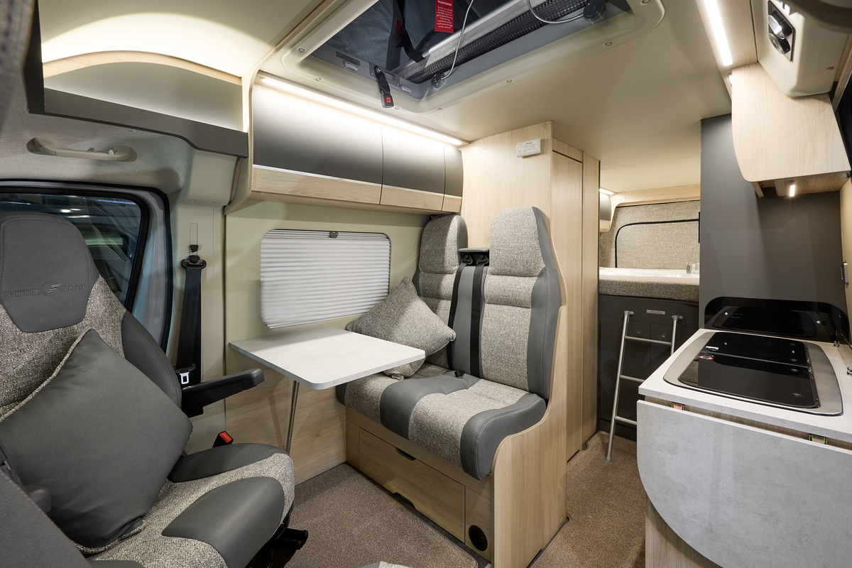 Auto-Trail Expedition 68's interior has two tone grey leather and fabric.  The furniture is wooden and the rear seats have fitted seatbelts.  There is a fixed bed to the rear with a ladder to gain easy access. The kitchen sink and hob is to the right