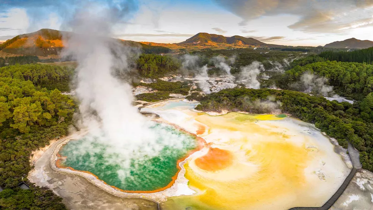A view from above Rotorua with steam rising high above the green hot springs water