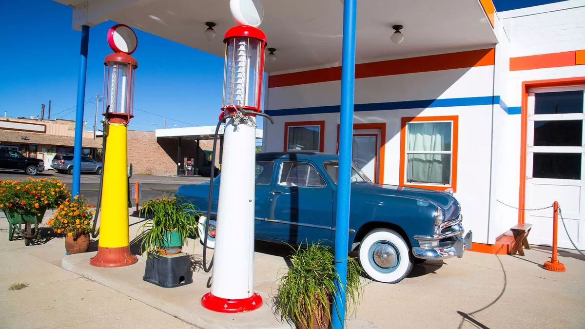 An retro style gas station with an old style car parked outside