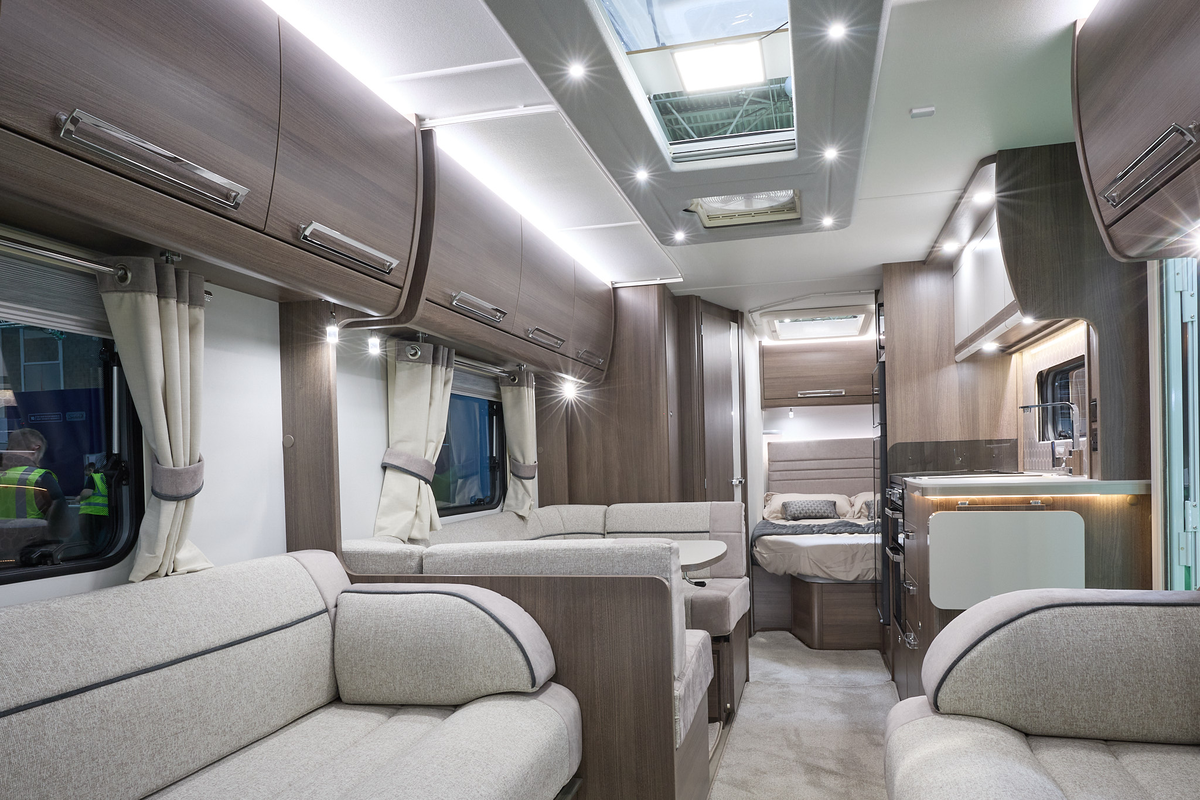 Buccaneer Aruba interior, cream upholstery, dark wood furniture and overhead lockers, skylights, lounge, dinette, kitchen, bedroom, fixed bed
