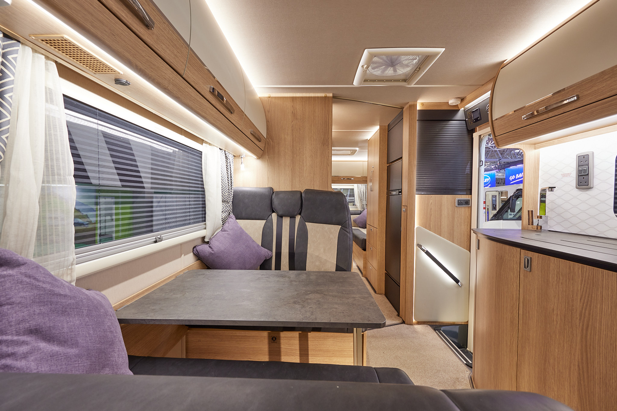 Auto-Trail Frontier Scout has two tone upholstery, with wooden furniture.  The floor has beige carpet.  The overhead lockers are cream with wooden surrounds.  There is an extractor fan in the middle of the vehicle.  