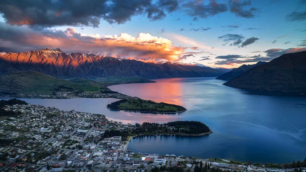 A view from above under an evening sky of the buildings below and the water surrounding