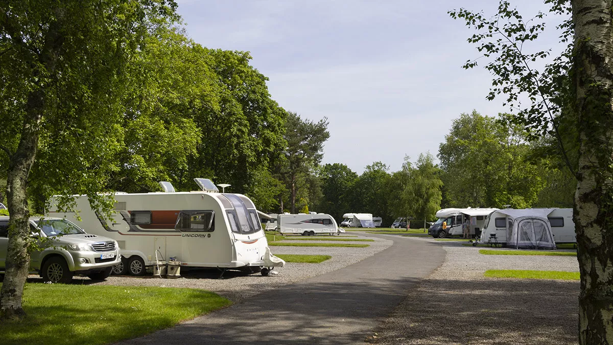 Overview of outfits pitched on hardstanding with awning pitches.