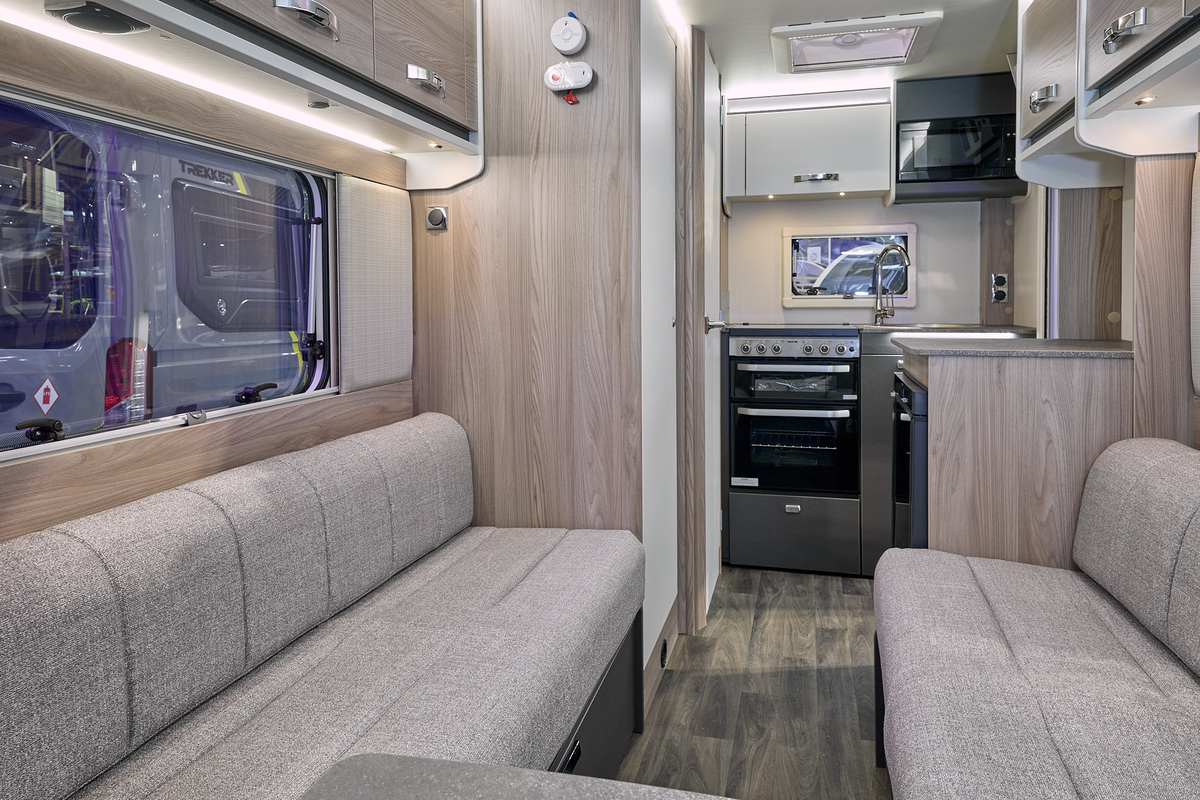 Swift Sprite Exclusive Compact’s interior has wooden furniture with beige furniture.  There is a kitchen to the rear with an oven, a sink and a microwave