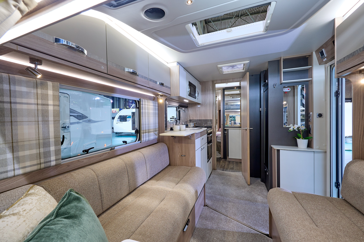 Swift Challenger Exclusive 650's interior has pale wooden furniture with beige upholstery.  The washroom is in the centre of the caravan with the bedroom at the rear.
