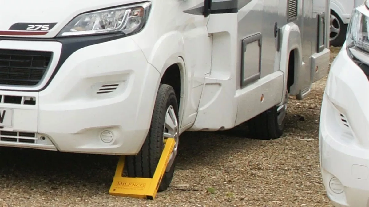 yellow Milenco wheel clamp on the front wheel of a motorhome