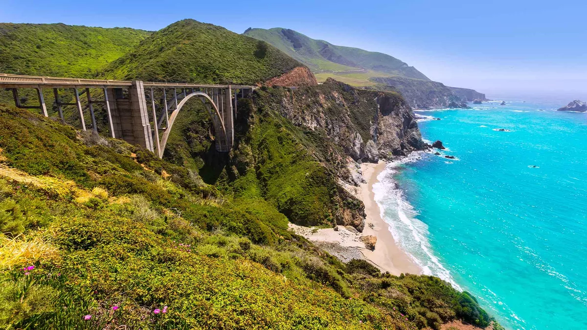 Bixby bridge stretching across along the left with the stunning turquoise ocean to the right 