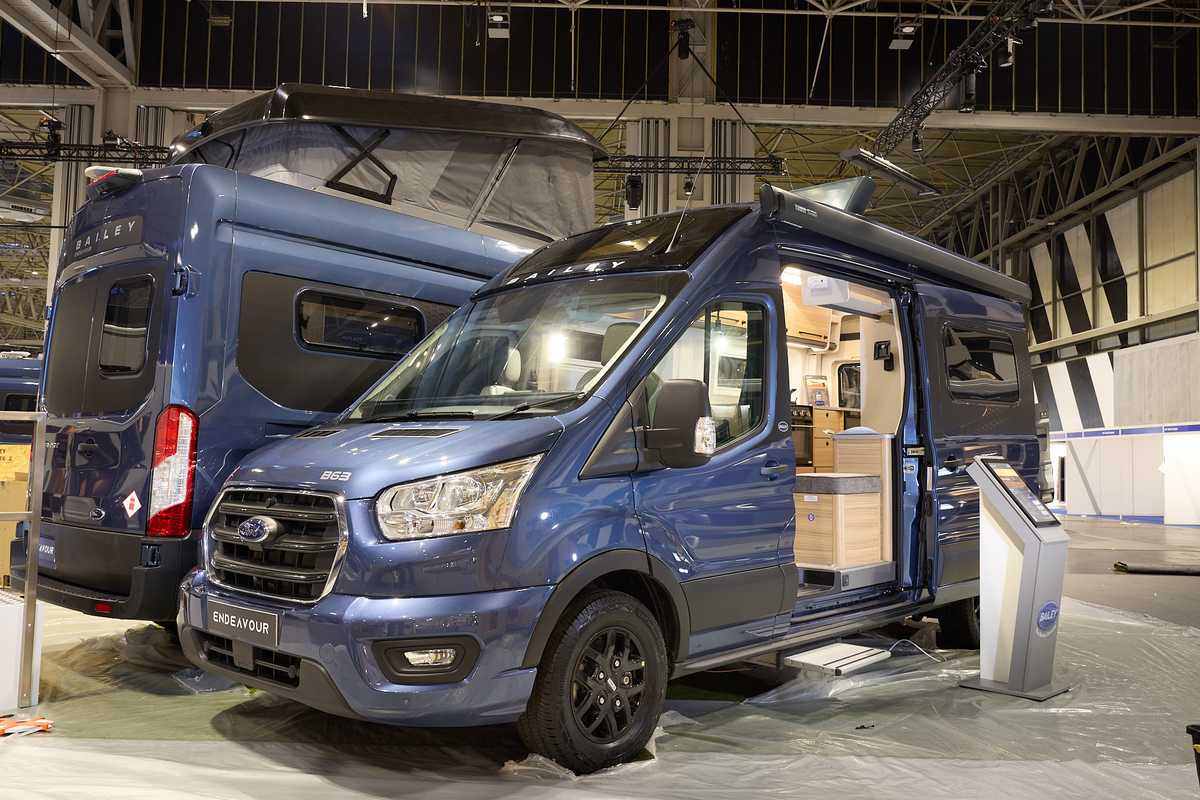 The Bailey Endeavour B63 is blue with black trim.  There is an interactive stand by the open sliding door which reveals the interior.  